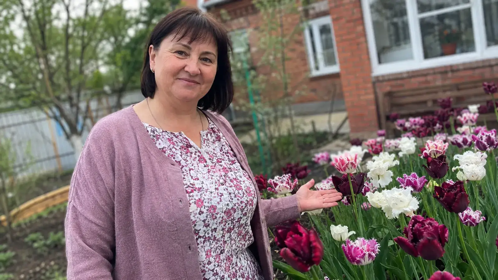 Молода жінка фотографує яскраву клумбу